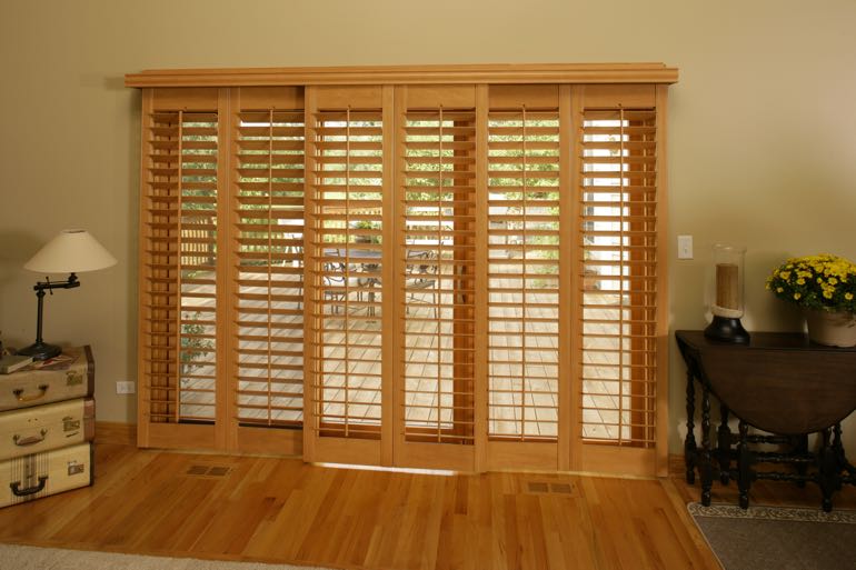 Faux wood shutters on sliding door going to outdoor porch.